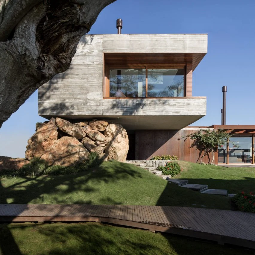 Fig House by Stemmer Rodrigues appears supported by a natural rock formation